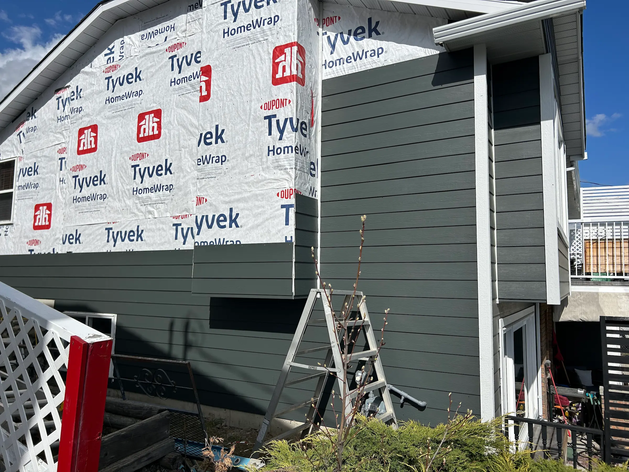 House under renovation with new siding being installed.